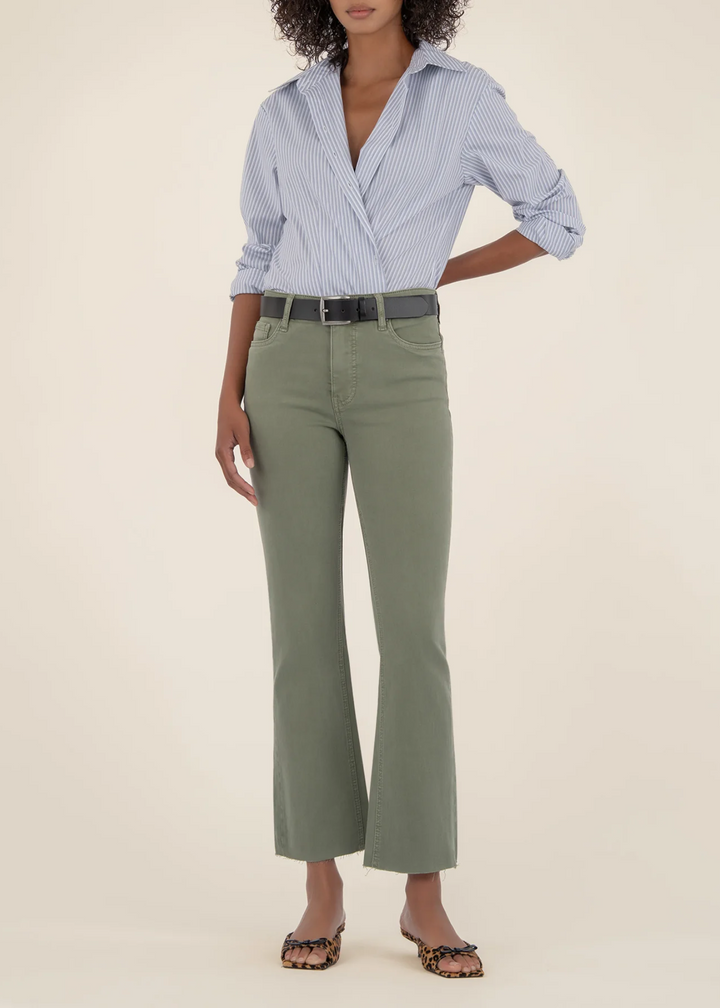 Woman wearing sage green flare jeans with a blue and white stripe button down