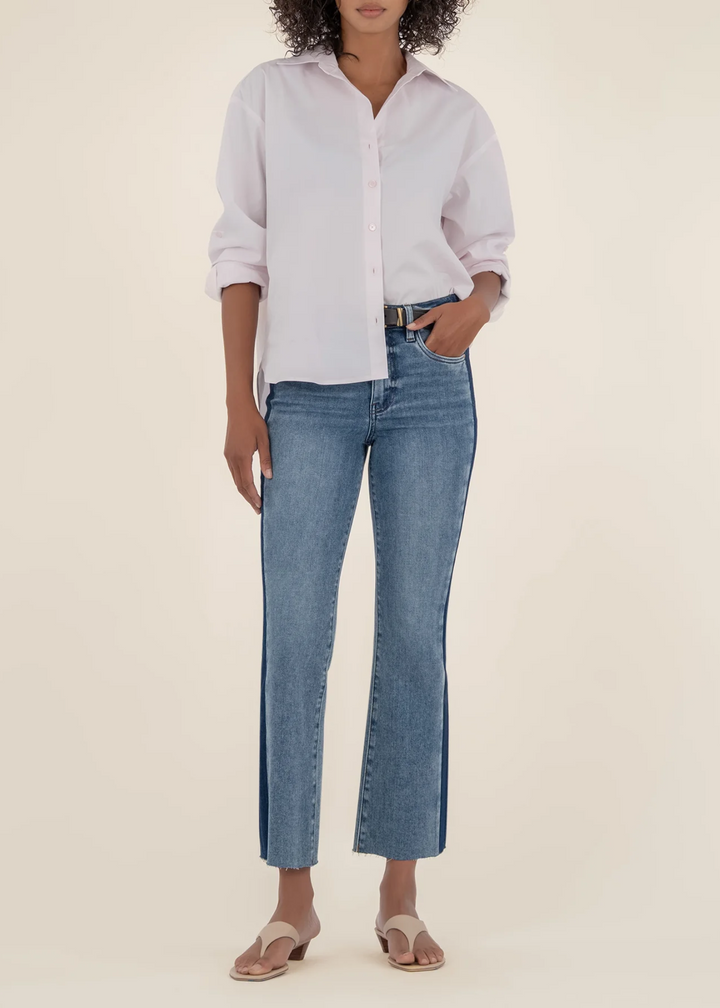 Woman wearing two toned flare jeans with a light pink button down shirt