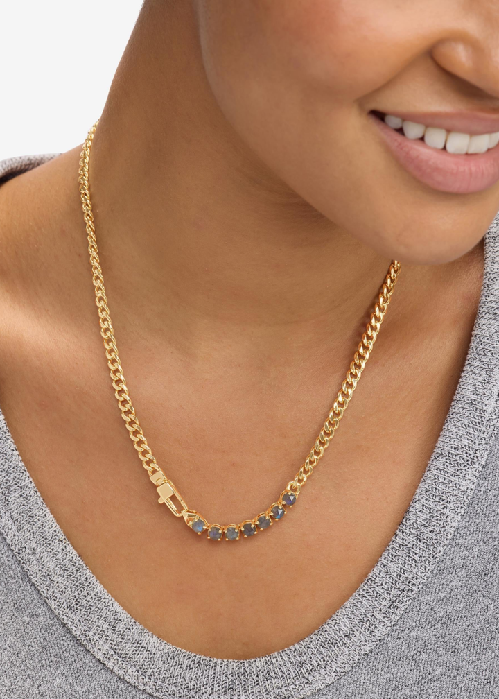 Woman wearing a gold chain necklace with seven labradorite stones
