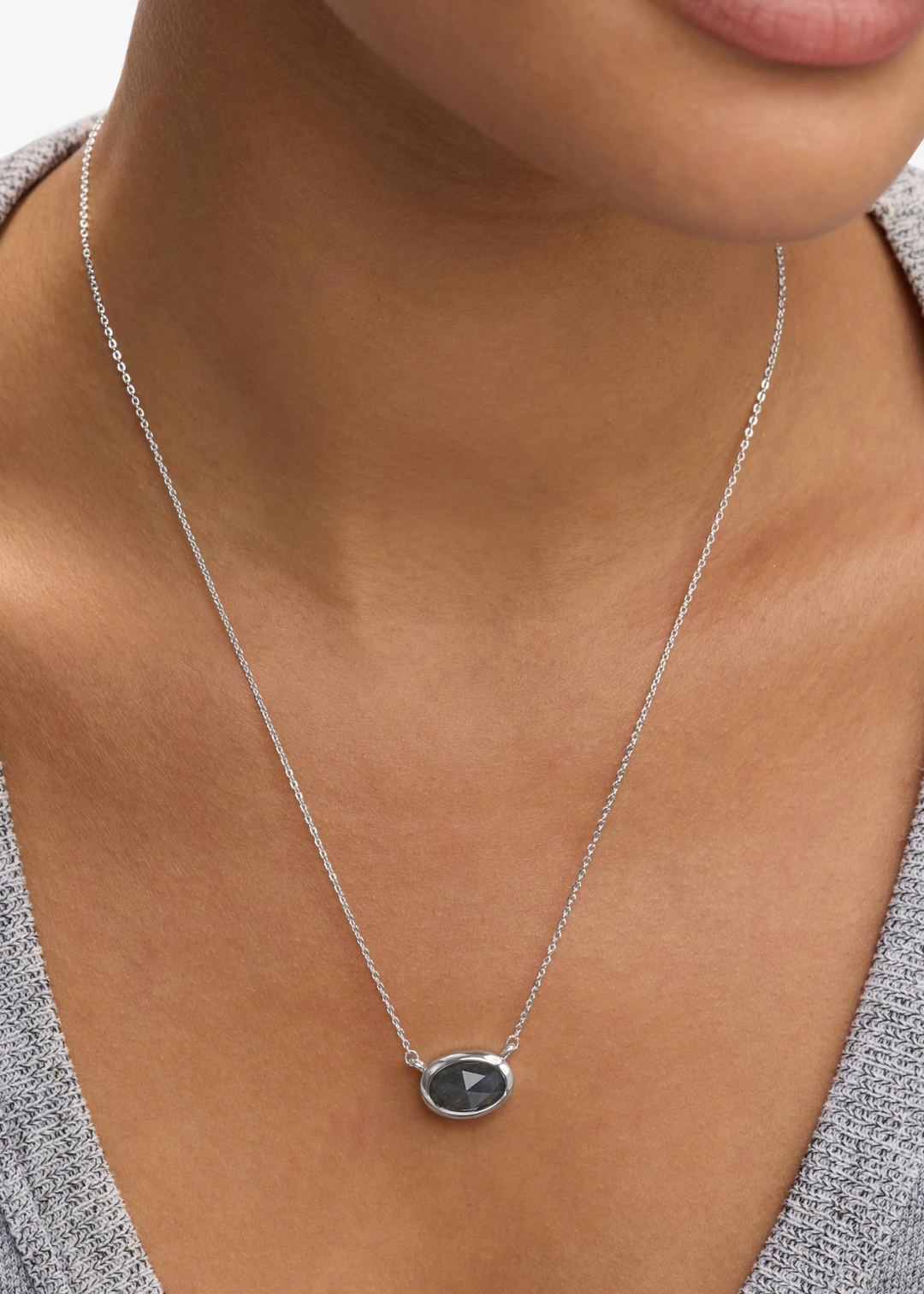 Woman wearing a silver framed labradorite pendant necklace