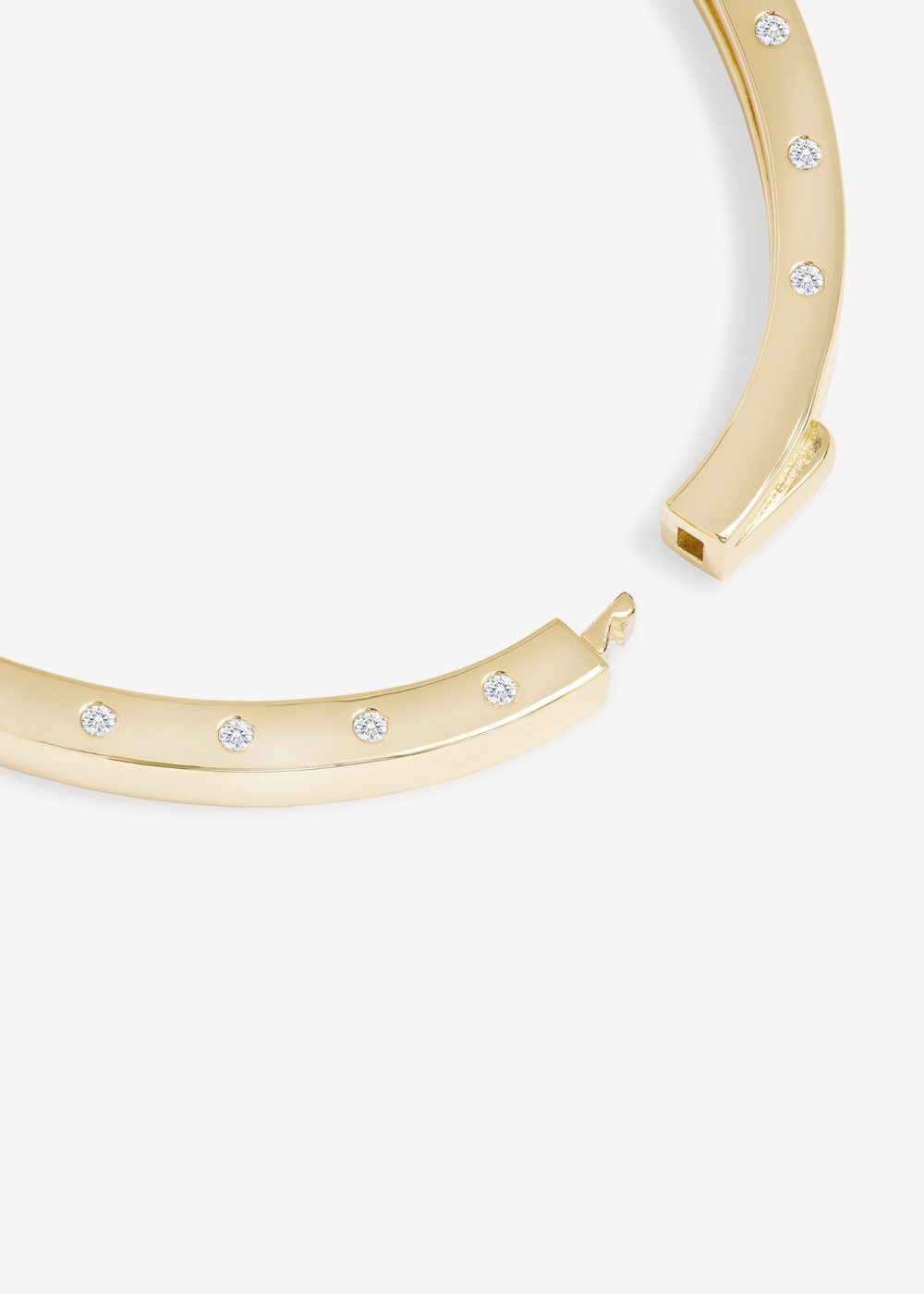 Gold cuff bracelet with a lock clasp on a white background