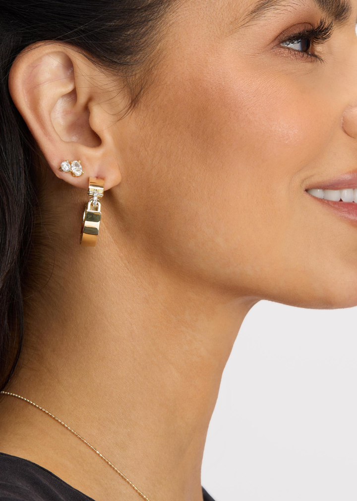 Woman wearing gold hoops with a lock design