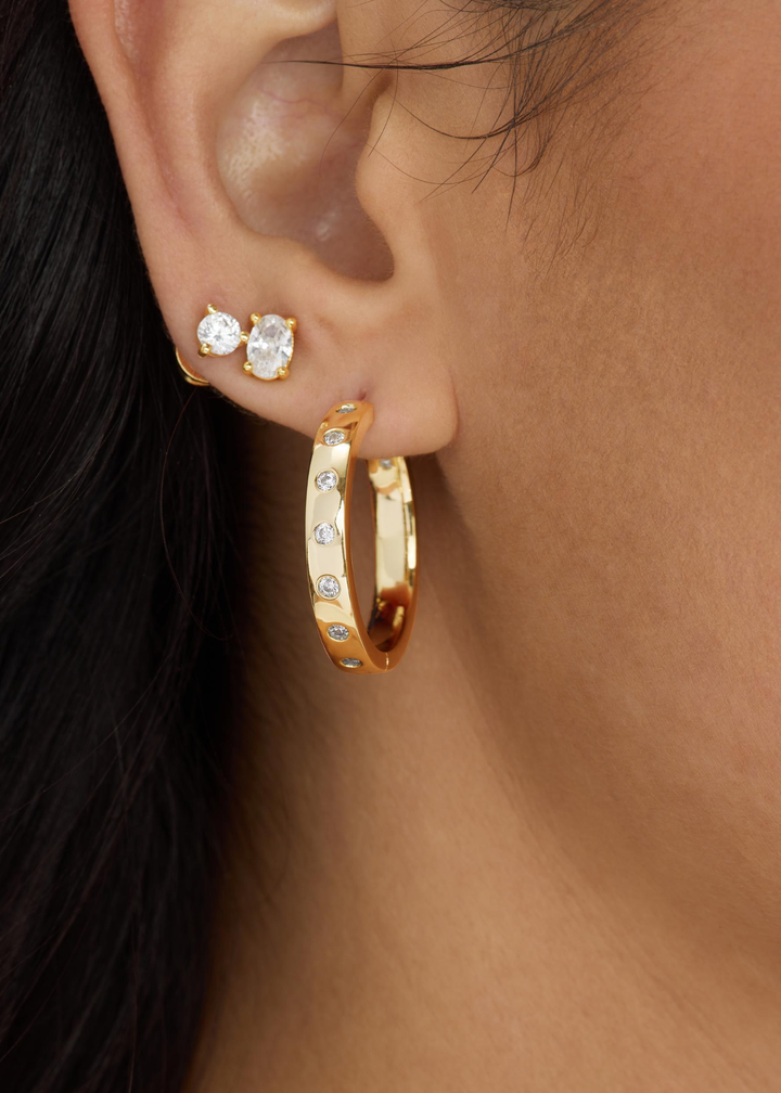 Woman wearing diamond studs and gold hoops with CZ studding