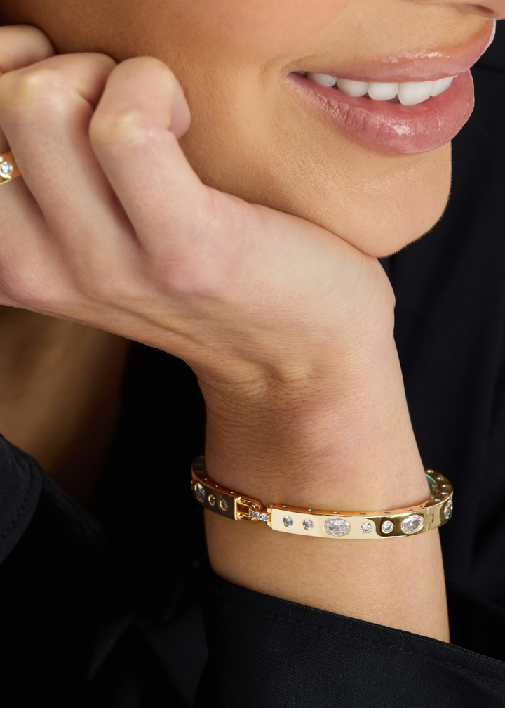 Woman wearing a gold cuff bracelet with CZ studding