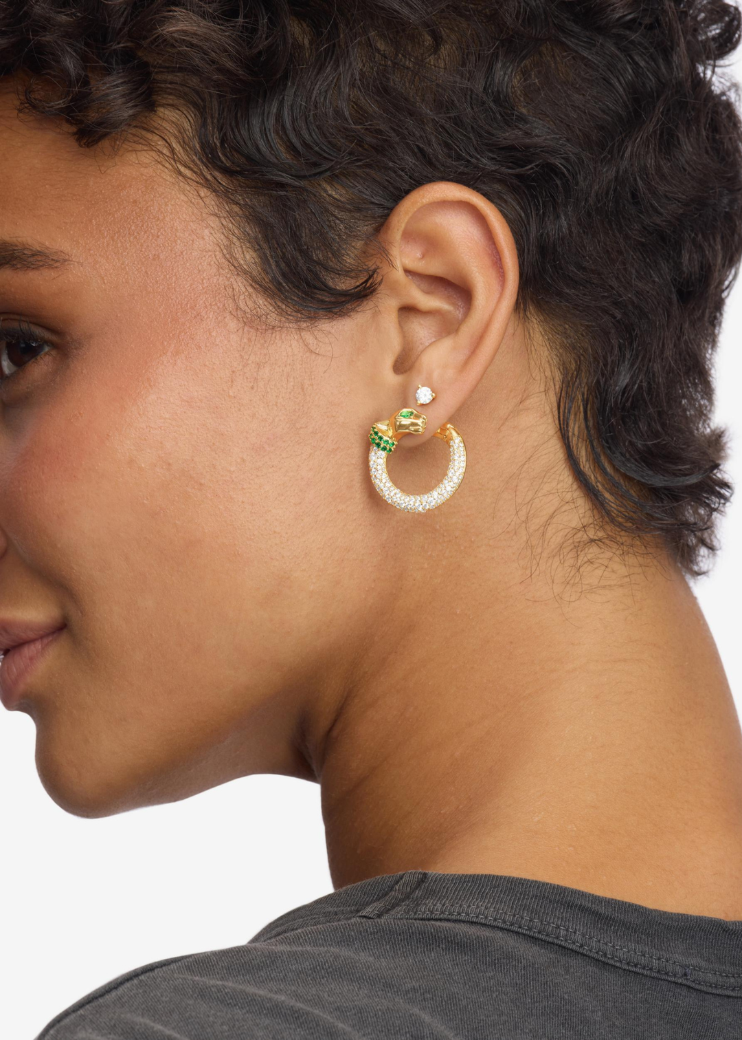 Woman wearing gold and emerald pave and jaguar shaped hoop earrings