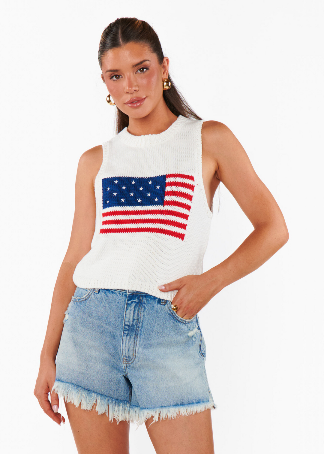A woman wearing a white knitted tank with an American flag graphic