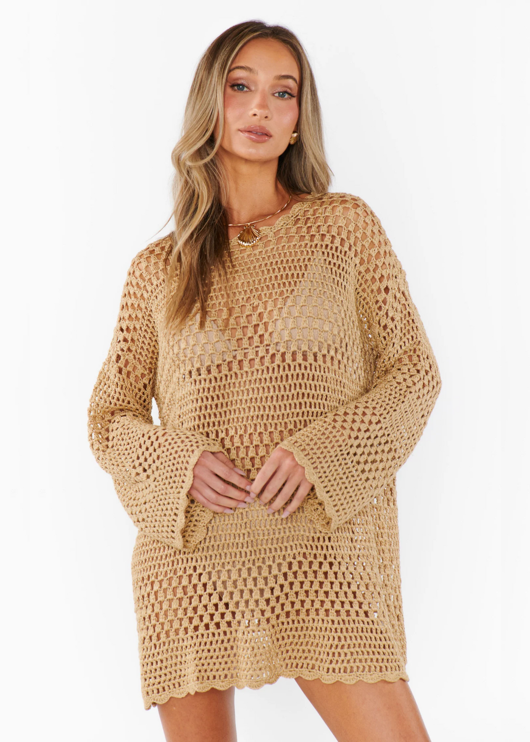 Woman wearing a crochet pullover in a latte color with open sleeves