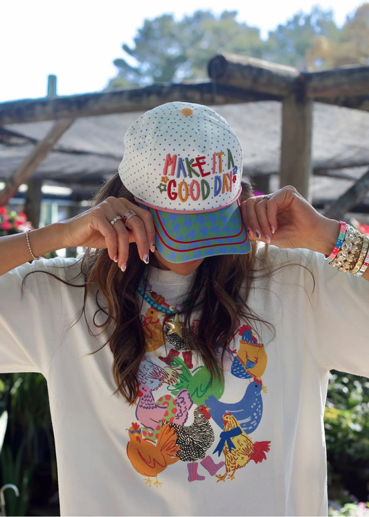 Woman wearing a hat with a "Make It A Good Day" graphic