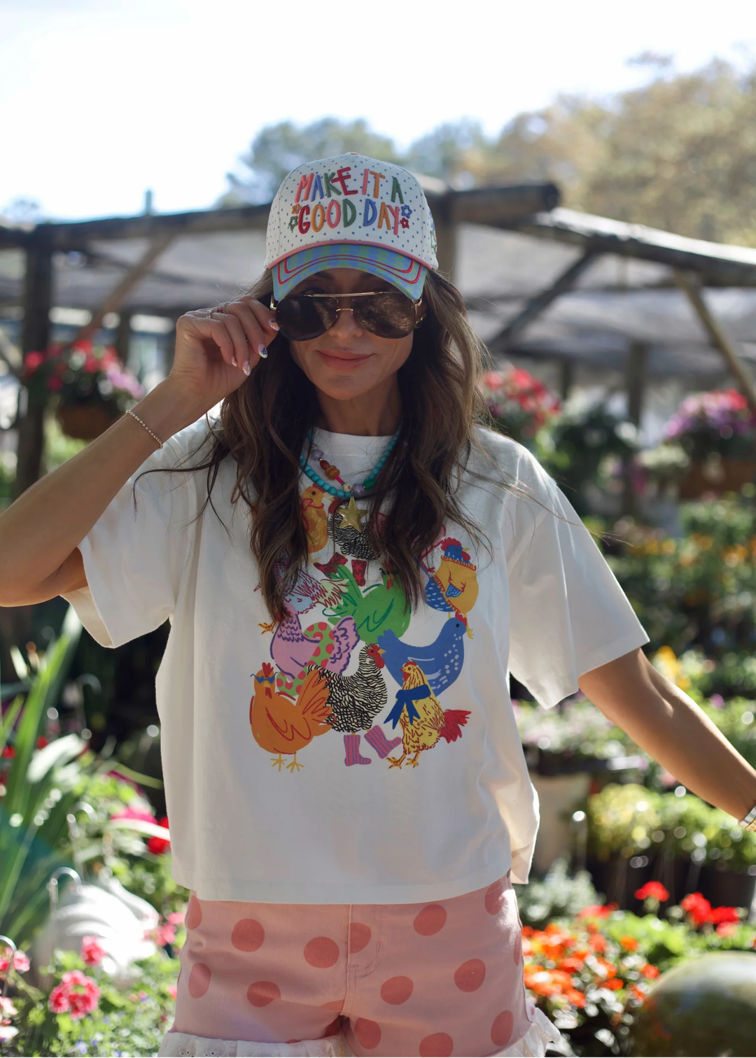 Woman wearing a hat with a "Make It A Good Day" graphic