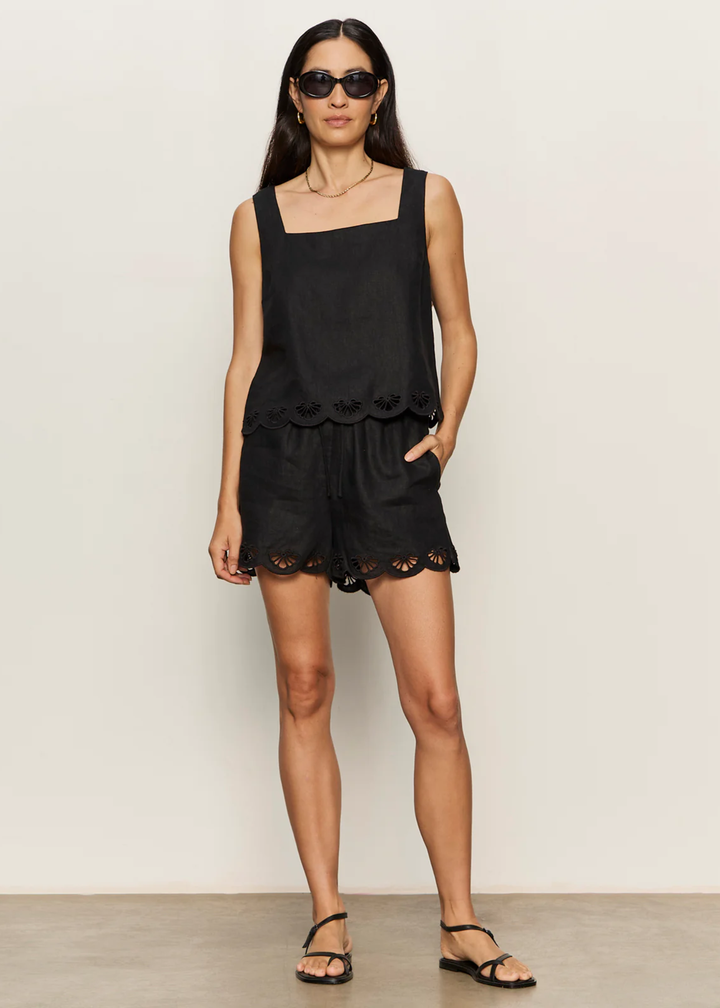Woman wearing a black tank with an eyelet hem and matching shorts