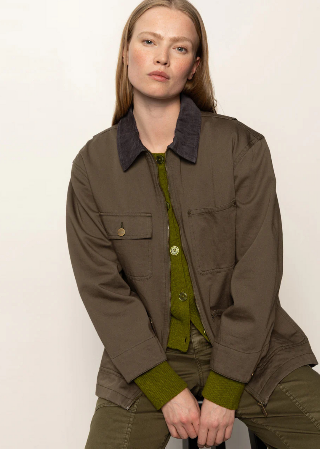 Woman wearing a burnt olive colored jacket
