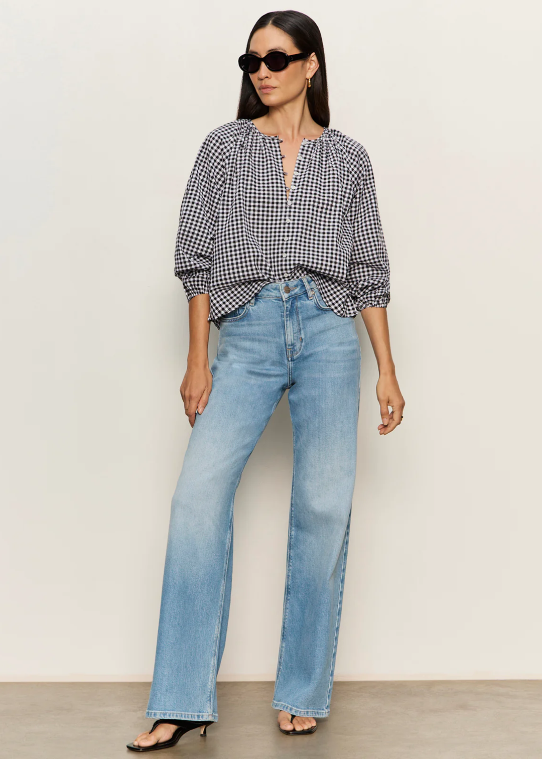 Woman wearing a black and white gingham top with jeans