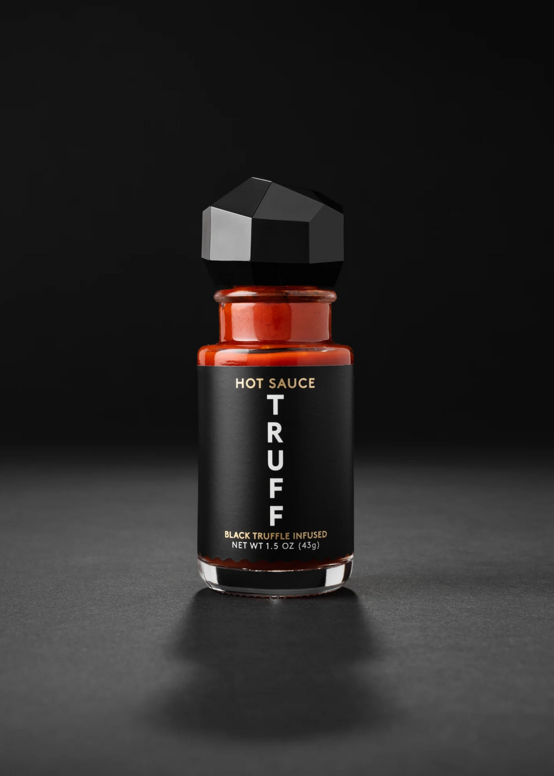 TRUFF mini hot sauce bottle on a black background