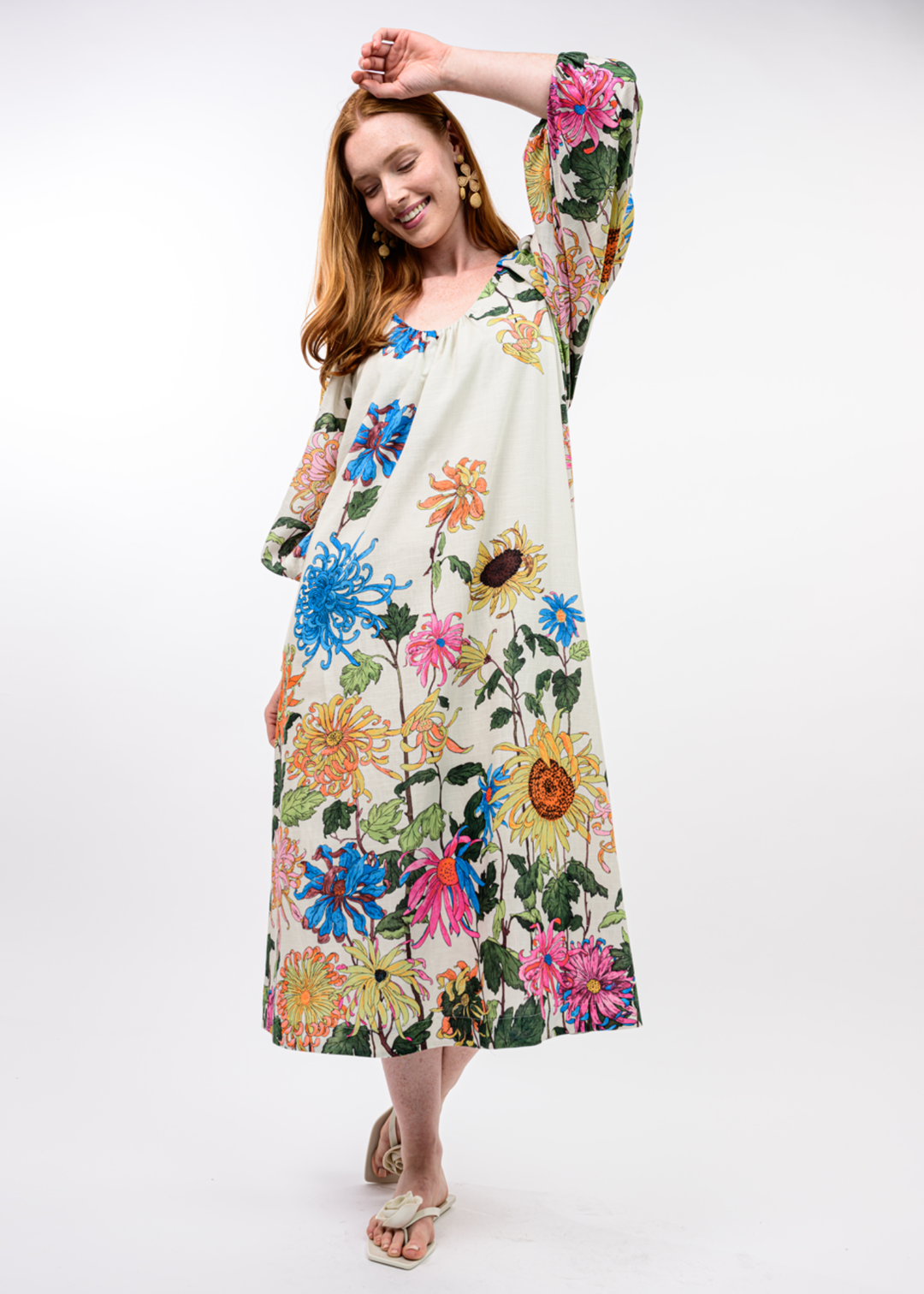 Woman wearing an ivory midi dress with a bright floral print
