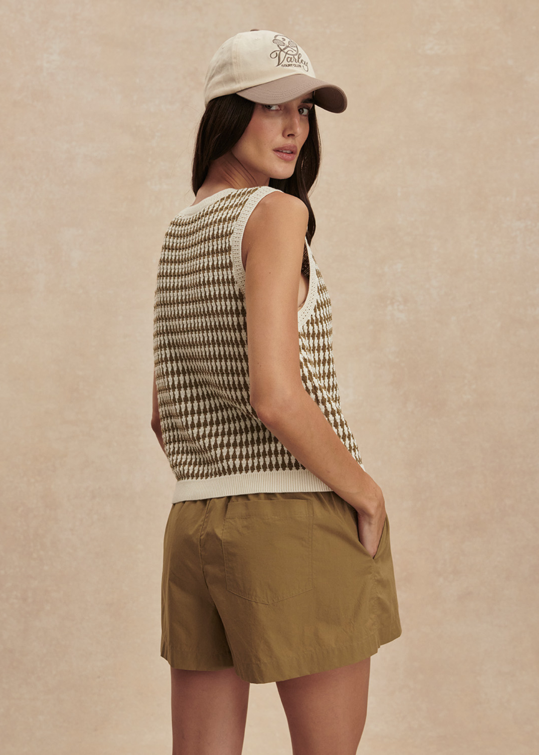 Woman wearing a brown and white knit button up tank top with matching brown shorts
