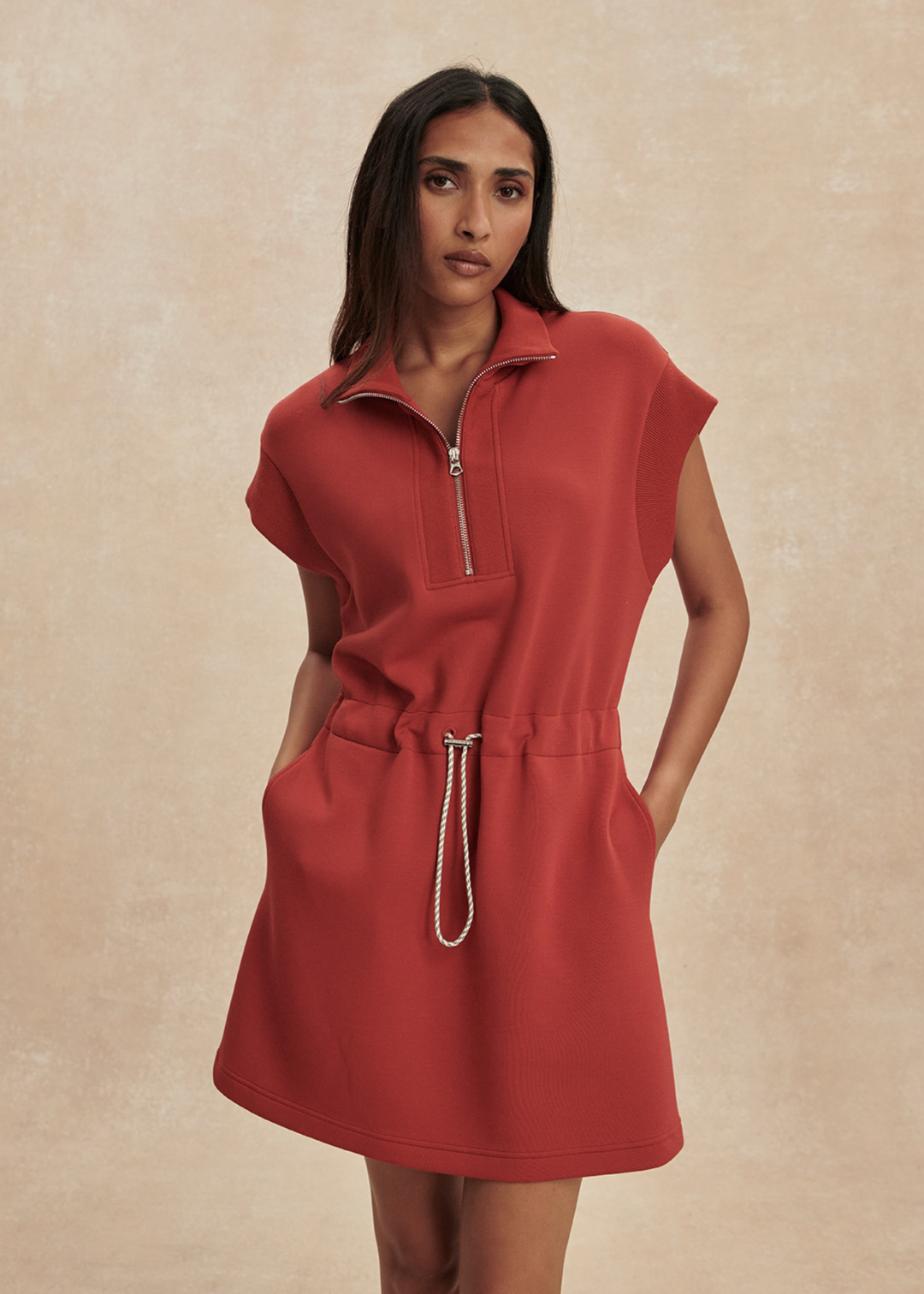 Woman wearing a red/orange half zip mini dress