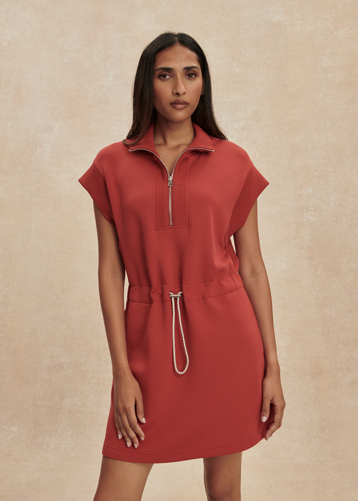 Woman wearing a red/orange half zip mini dress