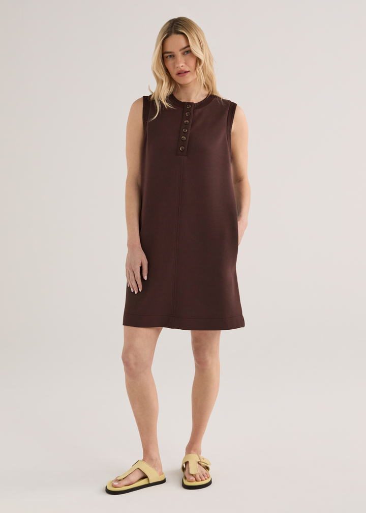 Woman wearing a brown sleeveless mini dress with yellow sandals