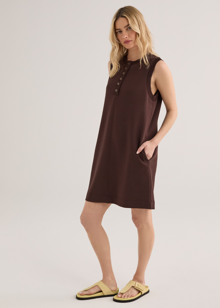 Woman wearing a brown sleeveless mini dress with yellow sandals