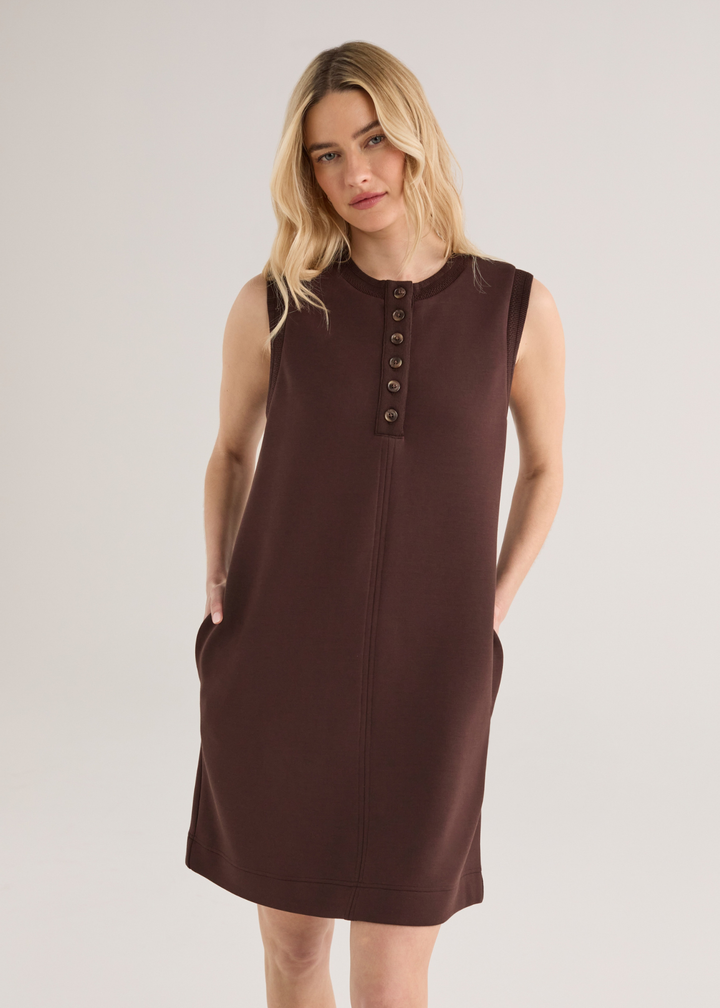 Woman wearing a brown sleeveless mini dress with yellow sandals