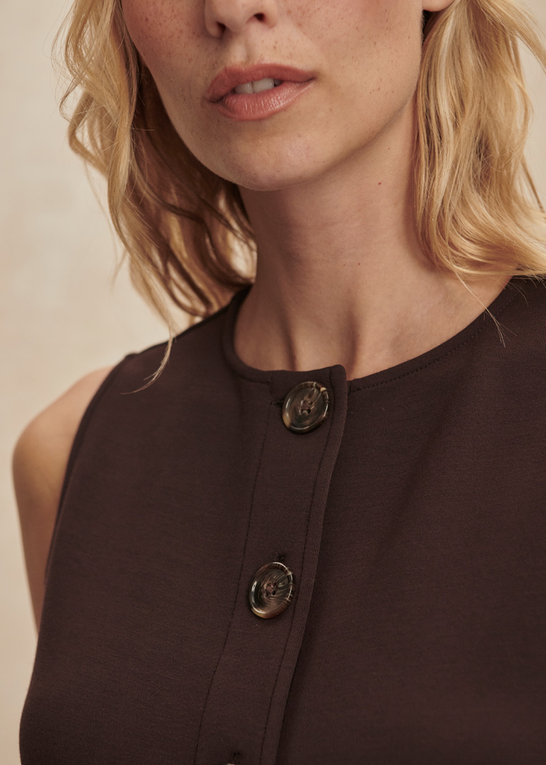 Close up of a woman wearing a brown button through tank with matching shorts