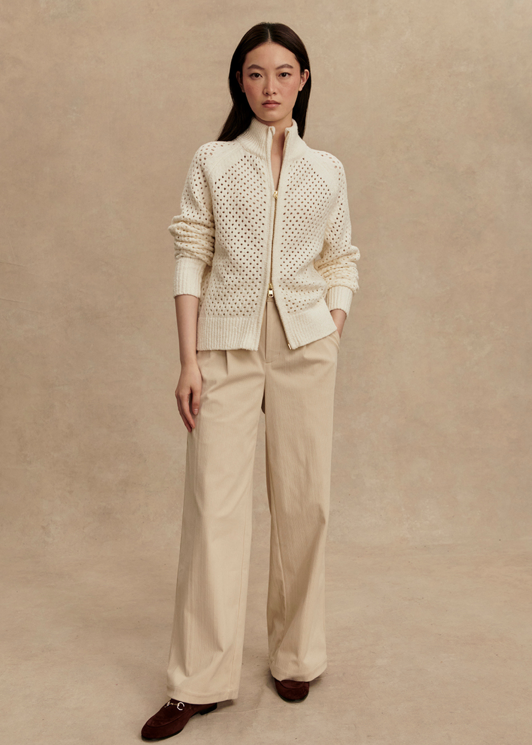 Woman wearing a cream colored boucle knit jacket