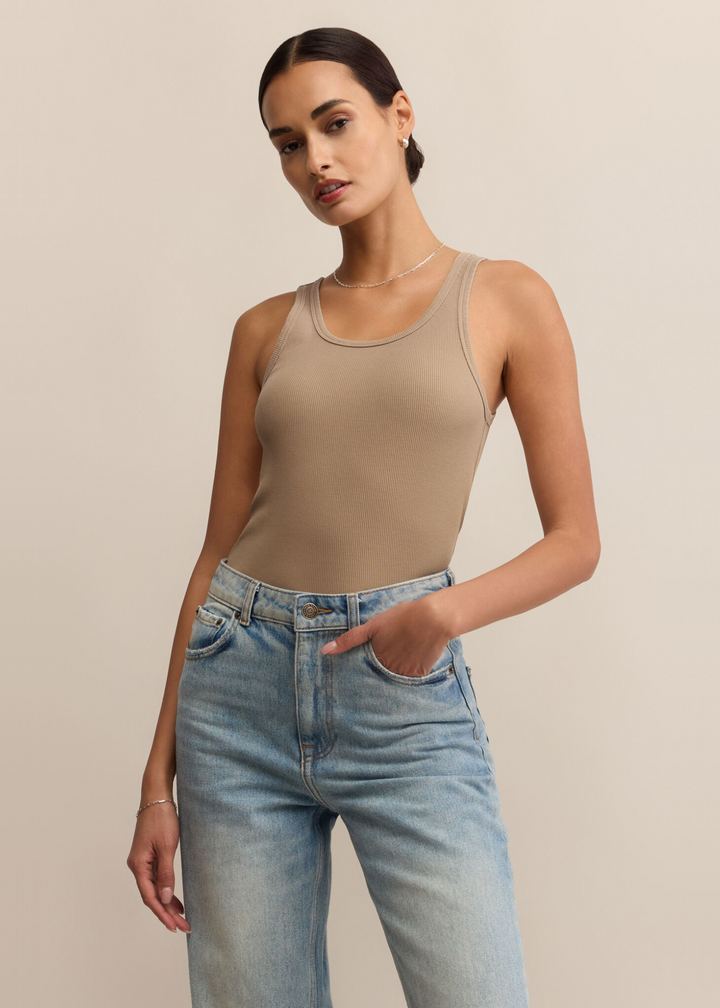 Woman wearing a tan tank top with a scoop neckline