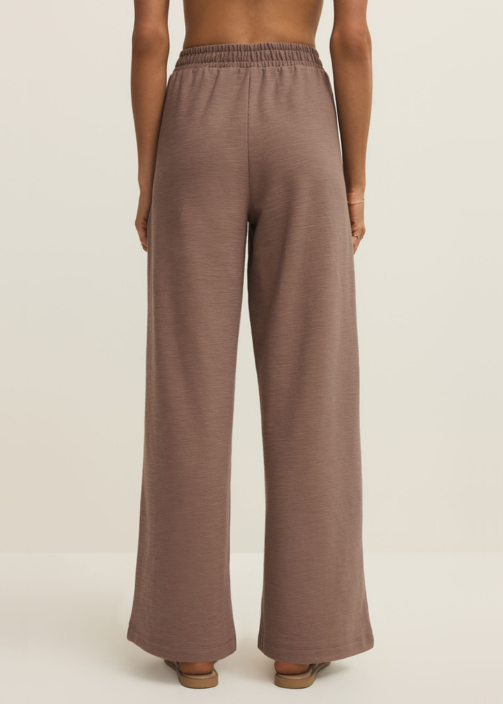 Woman turned around wearing brown knit wide leg pants