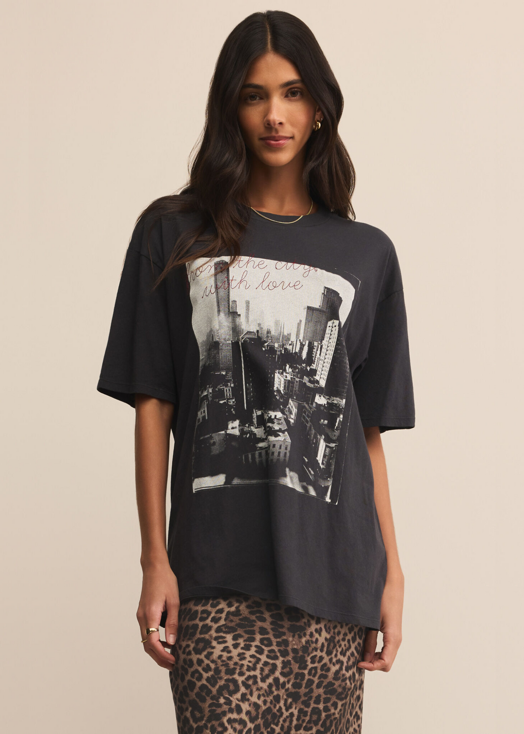 Woman wearing a New York City skyline graphic tee with red embroidered letters and a leopard print skirt