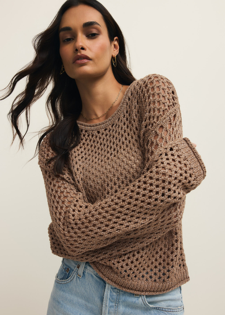 Woman wearing a brown shimmer sweater with jeans