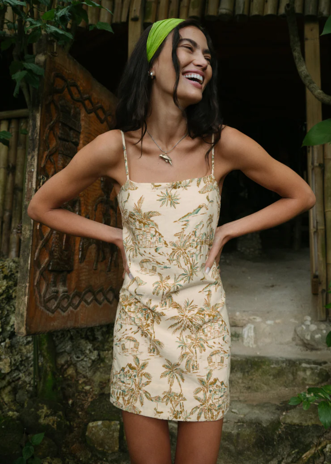 Woman wearing a cream mini dress with a tropical print