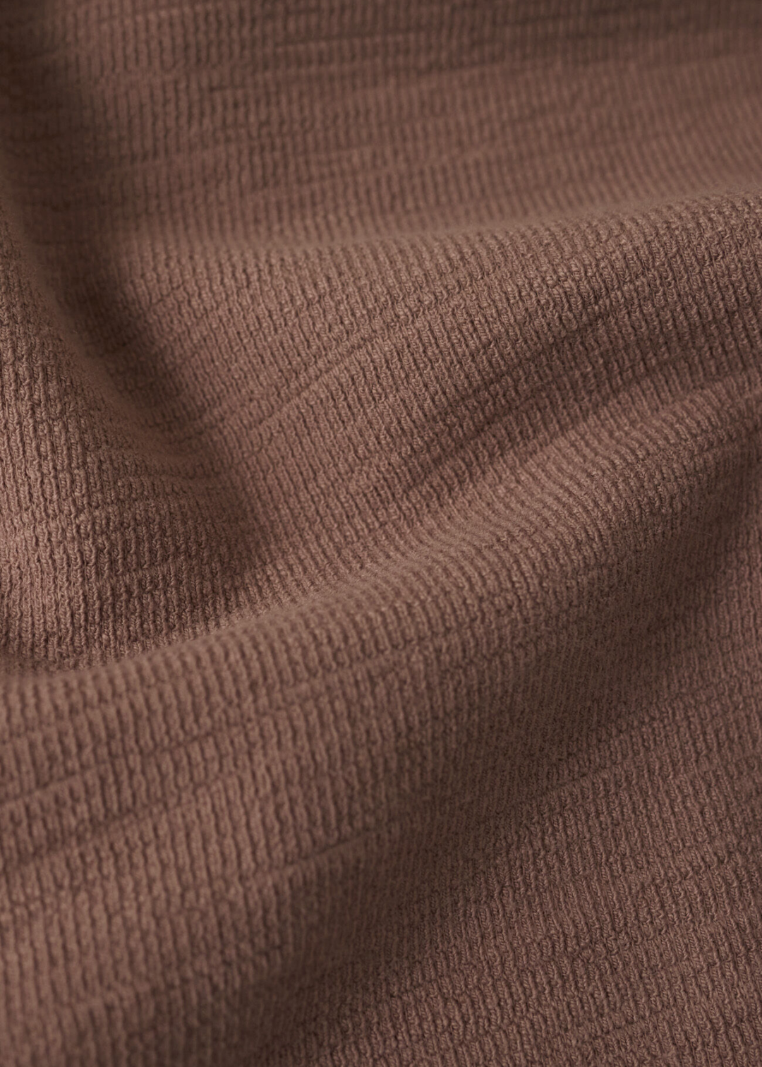 Close up of a brown textured knit fabric