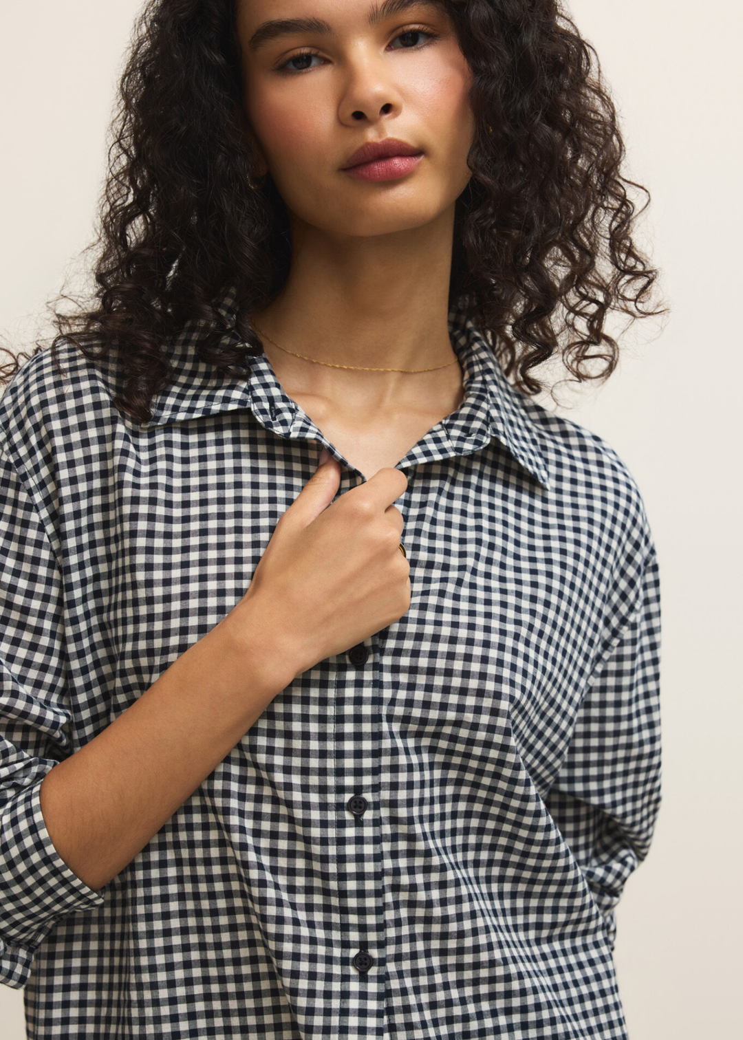 Close up of a woman wearing a navy and white gingham button down
