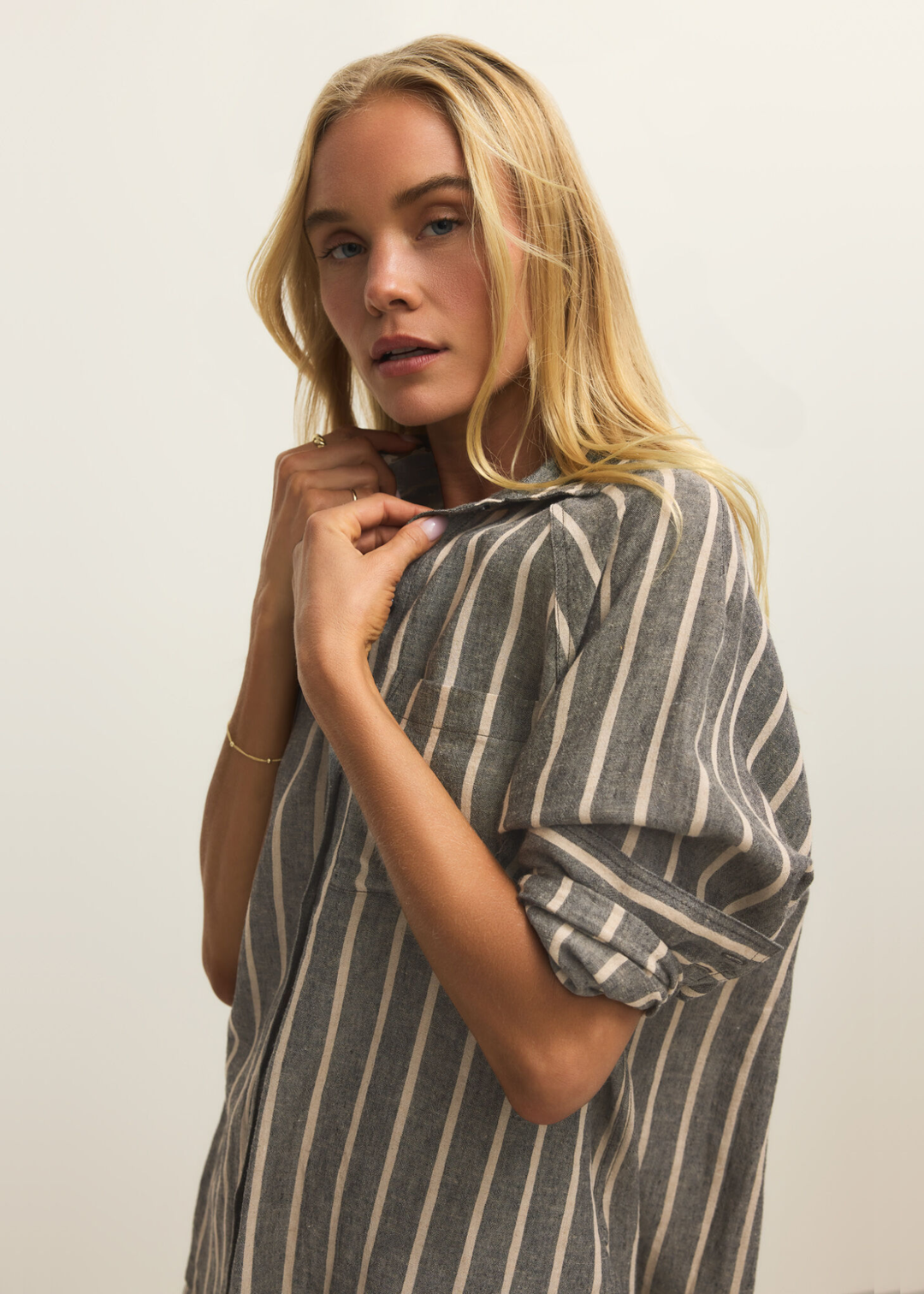 Woman wearing a black button down with white stripes and matching shorts