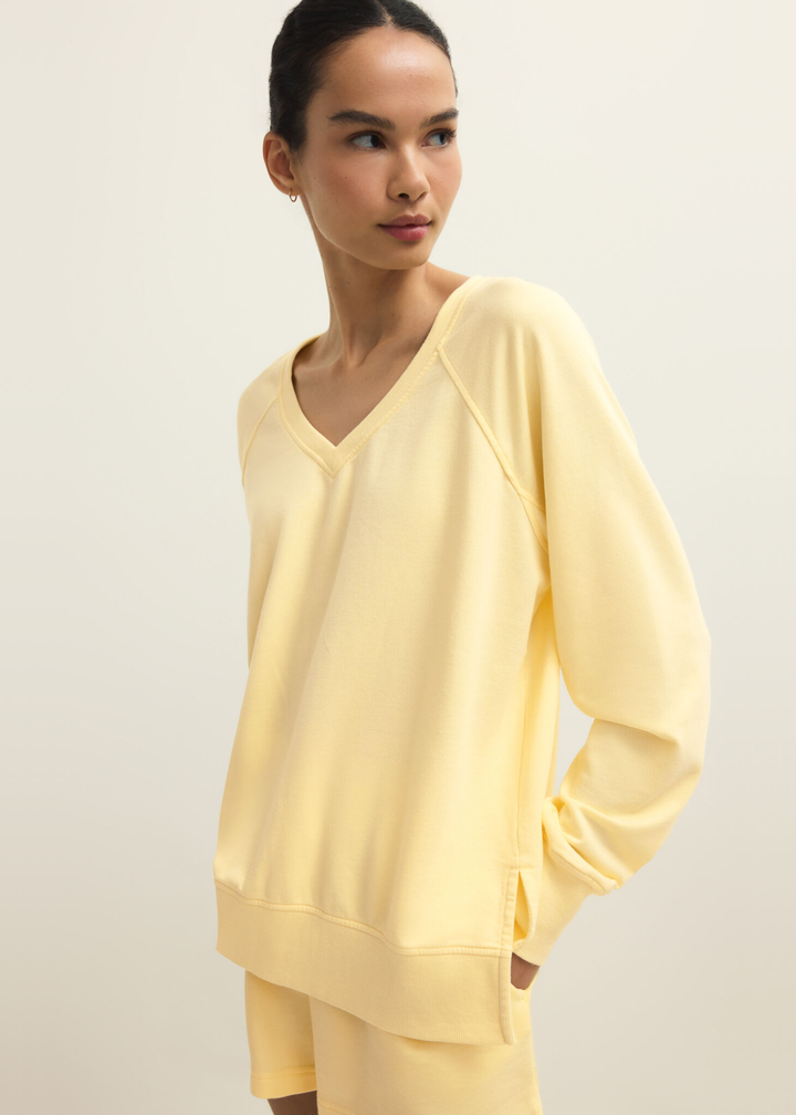 Woman wearing a yellow v-neck sweatshirt with yellow shorts