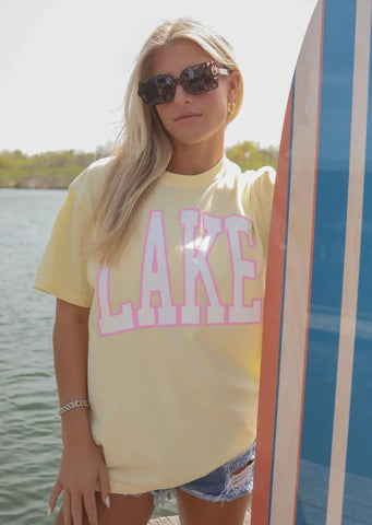 yellow oversized tee with "LAKE" printed in white varsity letters with pink outline