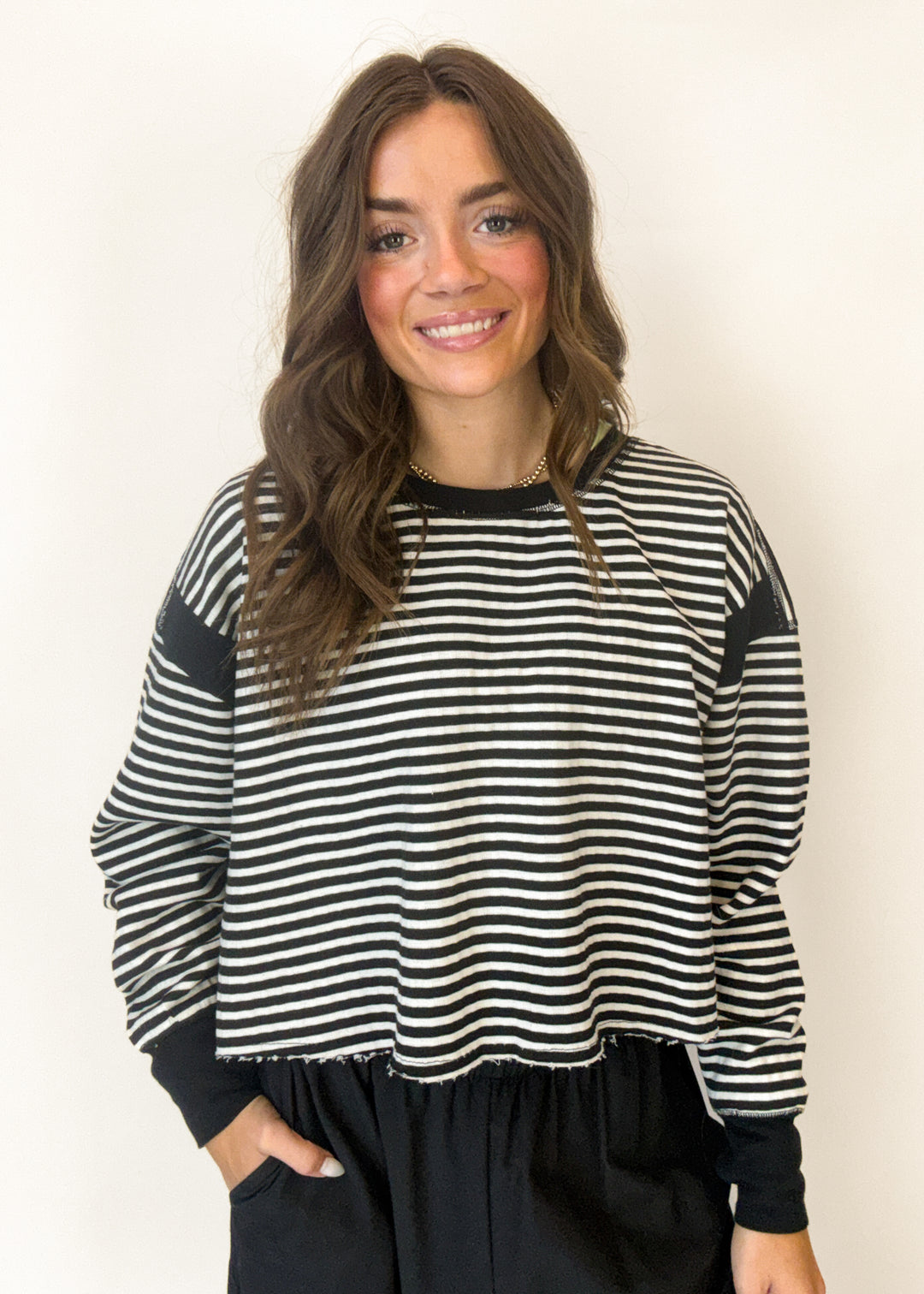 Woman wearing a black and white striped tee against a plain background