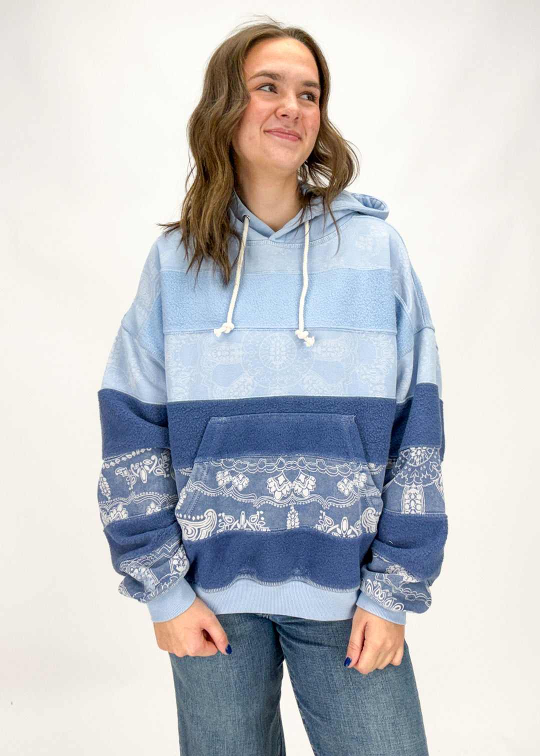 Woman wearing a blue and white patterned hoodie on a white background