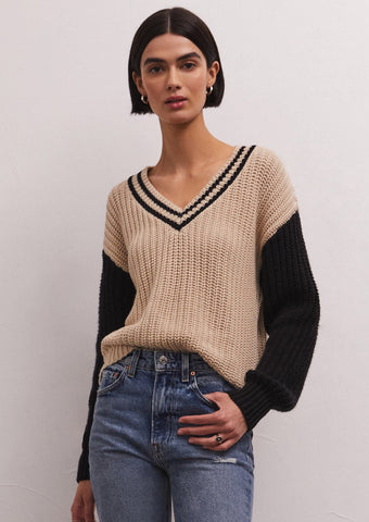 tan v neck varsity sweater with black stripe details at collar and black sleeves