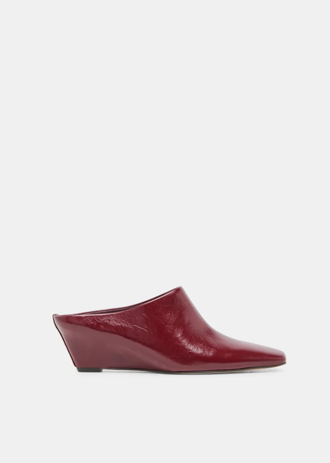 A single women's mule bootie in glossy burgundy leather, featuring a pointed toe and a low wedge heel, shown in profile against a light gray background.