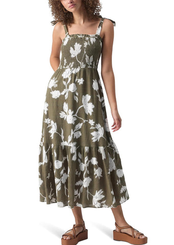 olive green midi dress with printed white floral pattern with smocked bodice, chest ruffles, tie straps, and tiered midi length skirt