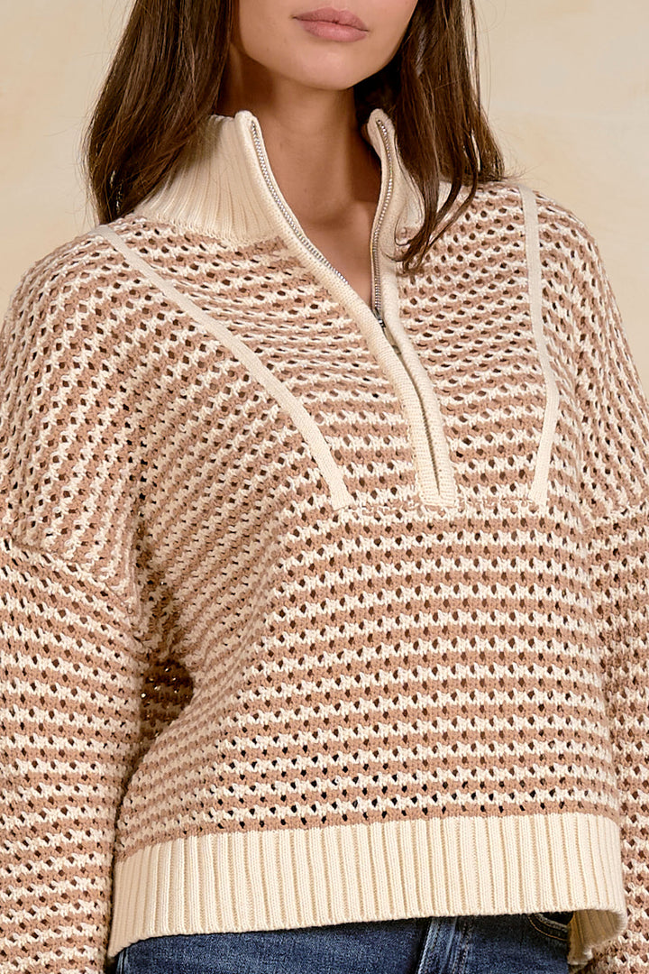 Beige patterned sweater with a zipper on a neutral background