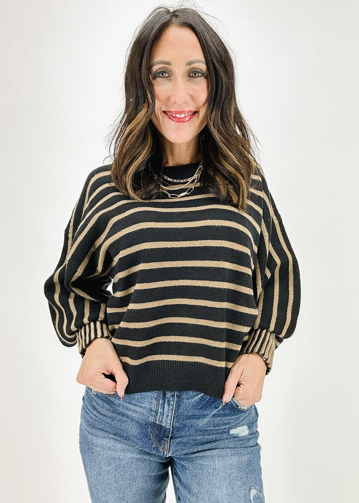 Women's black and brown striped sweater featuring a relaxed fit and stylish wide sleeves for a cozy yet trendy look.