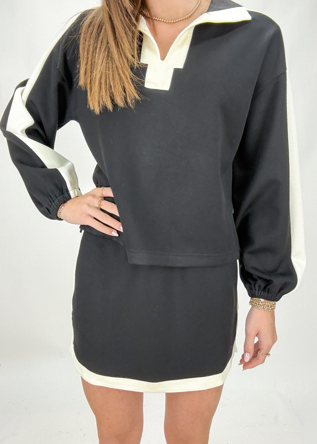 Black and white skirt and sweater worn by a person on a plain background