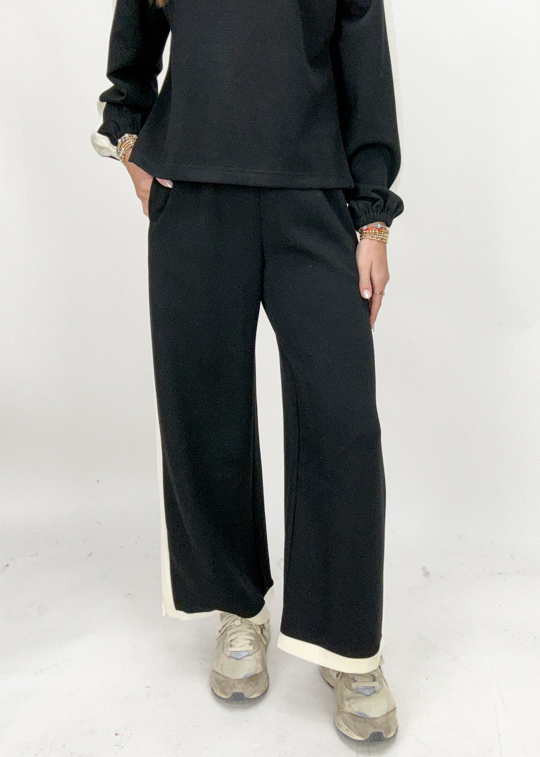 Person wearing black pants and a black top on a white background