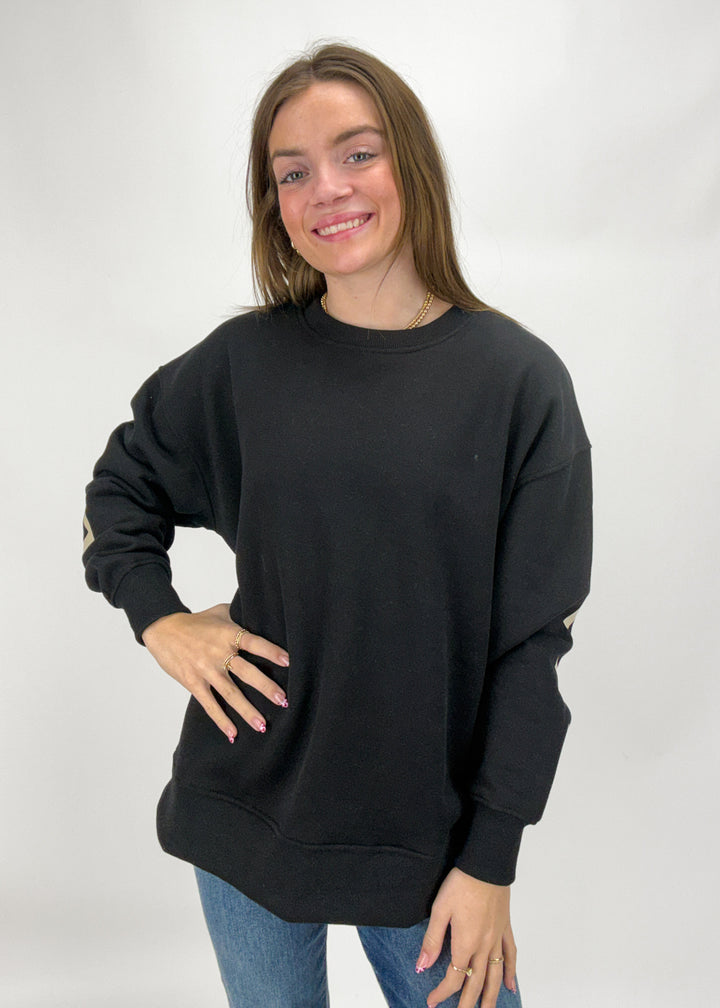 Woman wearing a black sweatshirt against a white background