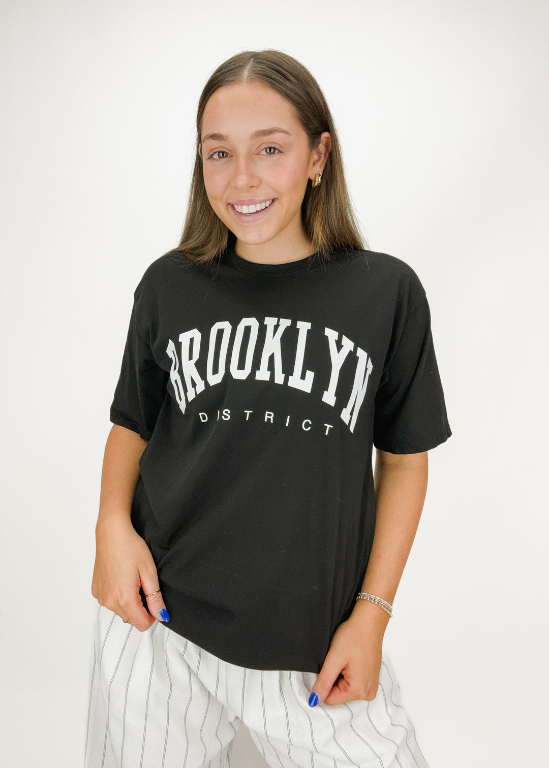 short sleeve black crew neck tee with white "Brooklyn District" varsity chest graphic