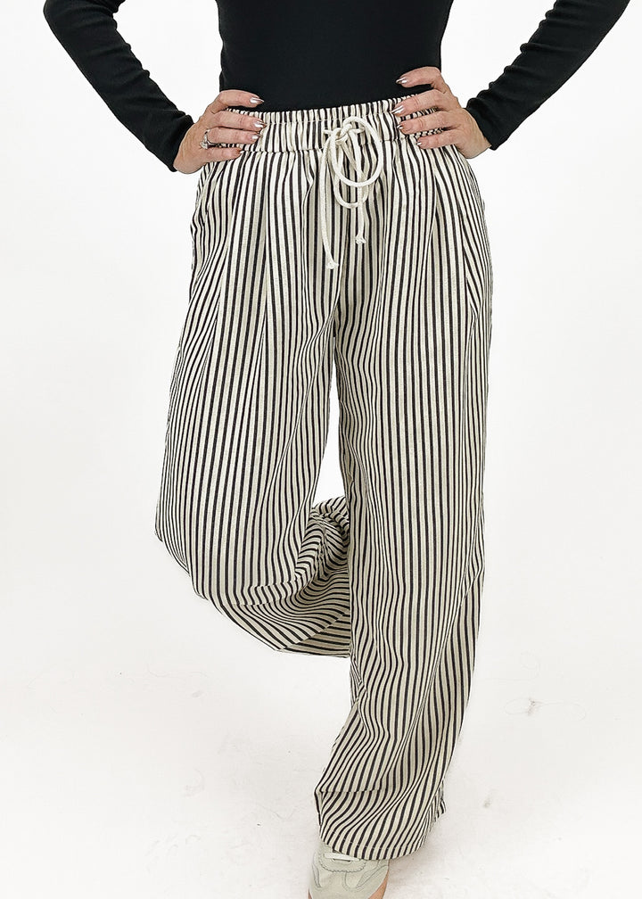 Women's black and white striped pants featuring a relaxed fit and adjustable drawstring waist for comfortable wear.