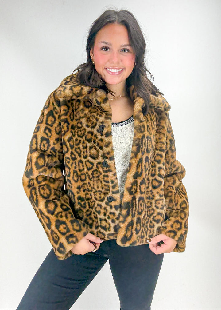 Woman wearing a leopard print jacket against a white background