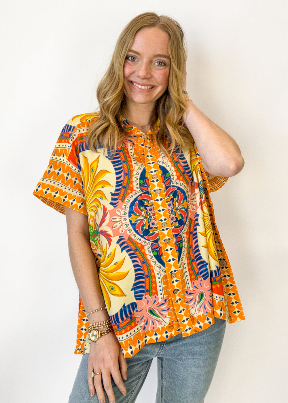 Woman wearing a colorful patterned shirt against a white background